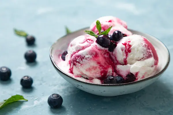 Schale mit Eis und Heidelbeersoße