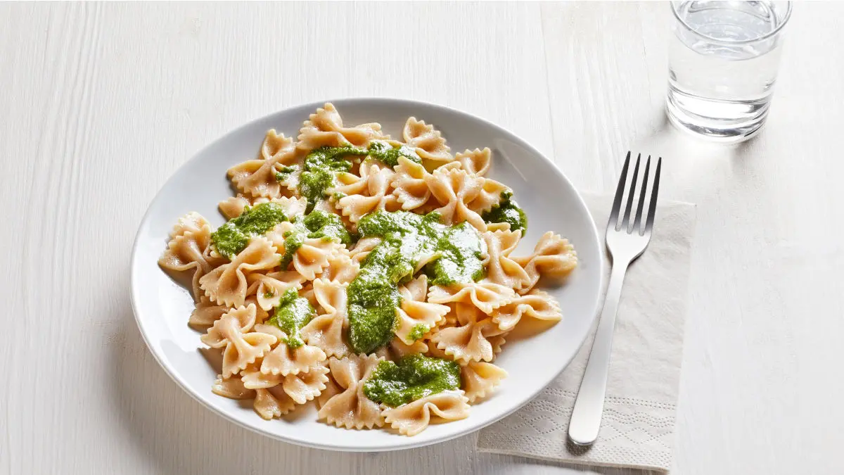Vollkornpasta mit selbstgemachtem Basilikumpesto auf tiefem Teller