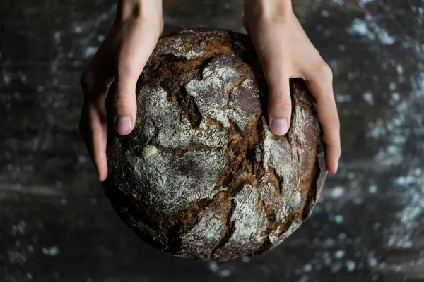 Ein Brot wird in zwei Händen gehalten