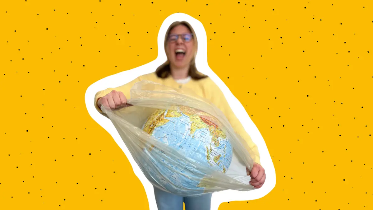 eine junge Frau zerreißt die Plastikhülle, in die ein Modell der Erde eingepackt ist
