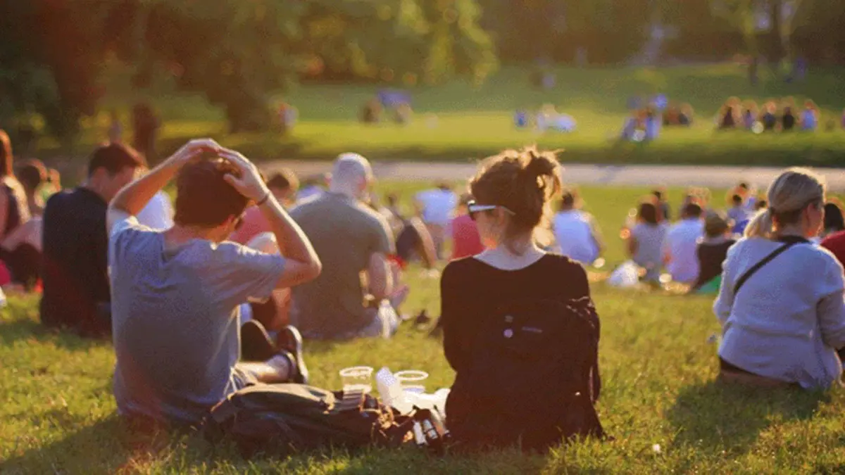 Junge Menschen in Abendsonne auf Wiese