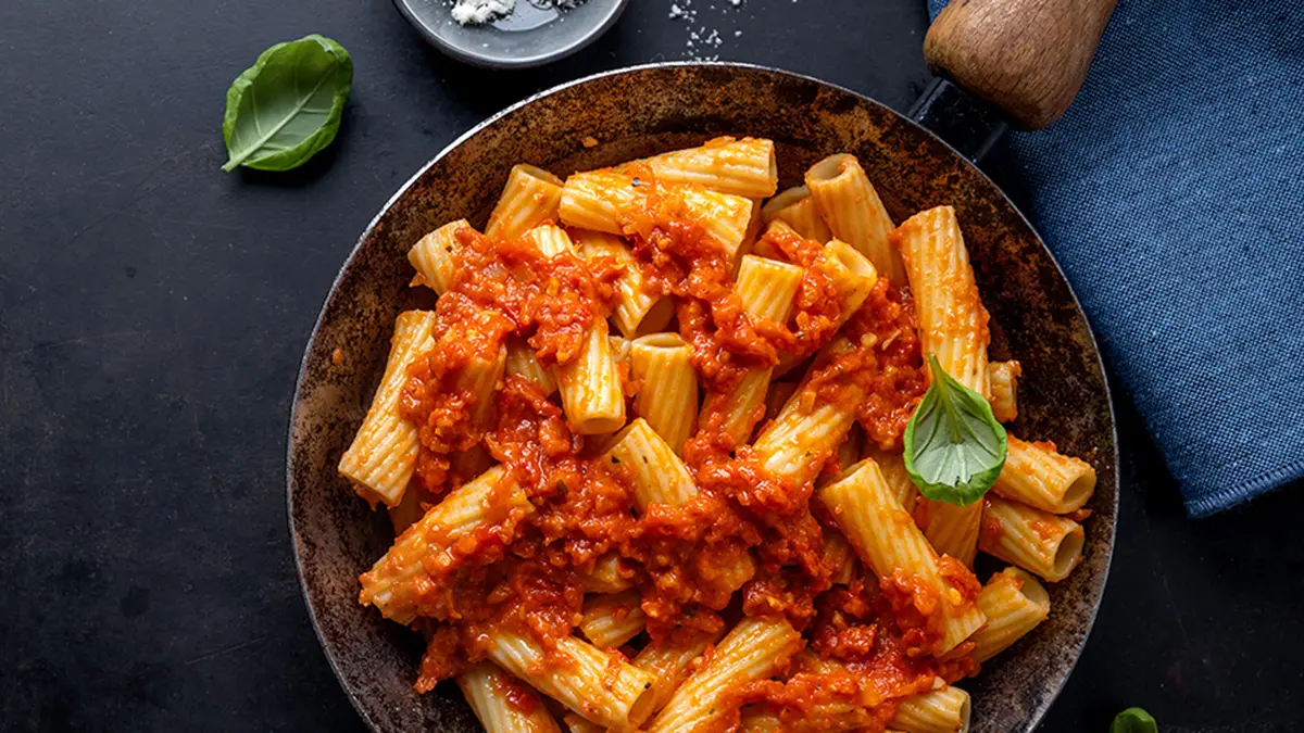 Nudeln in Tomatensauce auf einem dunklen Teller