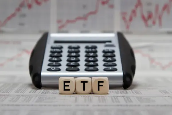 Taschenrechner und Holzwürfel mit Aufschrift ETF