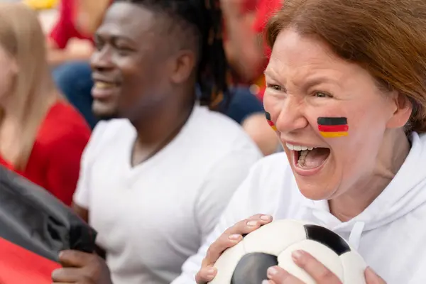 Nahaufnahme eines weiblichen Fußballfans mit bemaltem Gesicht