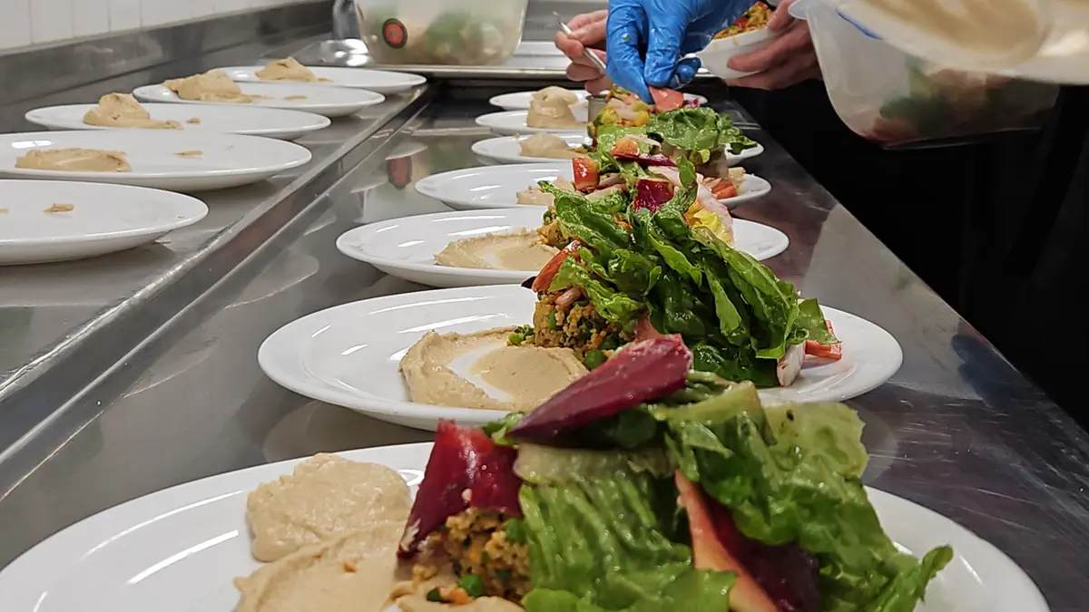 Ein Salat wird auf mehreren Tellern angerichtet