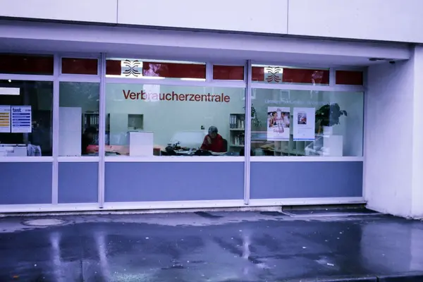 Eine Frau telefoniert hinter einer Schaufensterscheibe