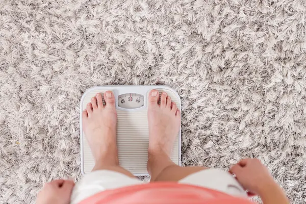 BMI-Rechner: Eine Person steht auf einer Waage