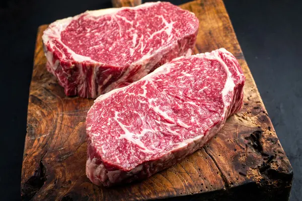 Zwei Stück Rindfleisch auf einem Holzbrett