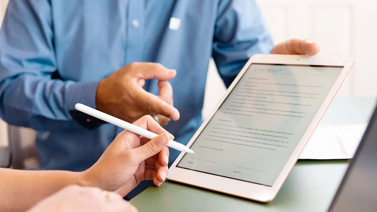 Vertreter reicht einer Frau ein Tablet zur Unterschrift