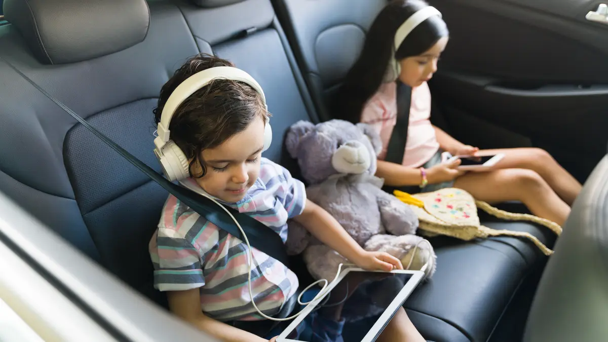 Kinder mit Tablet und Smartphone im Auto