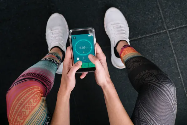 Sportmensch hält Fitness-App in der Hand