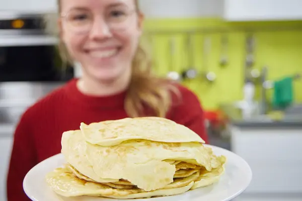 Junge Frau mit Teller mit Pfannkuchen
