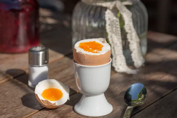 geköpftes Frühstücksei mit Salzstreuer auf einem Tisch