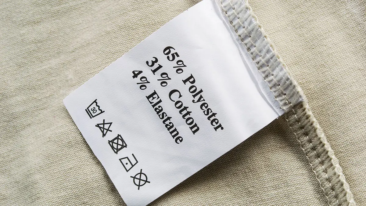Ein Wäscheschild mit den Angaben "65% Polyester, 31% Cotton, 4% Elasthane"