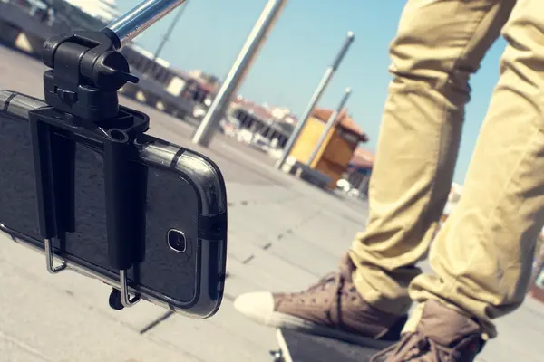 Sakteboarder filmt sich mit Handy auf Selfiestick 