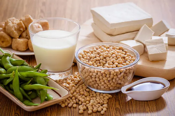 Sojabohnen, Sojadrink, Tofu und andere Sojaprodukte auf einem Tisch angerichtet  