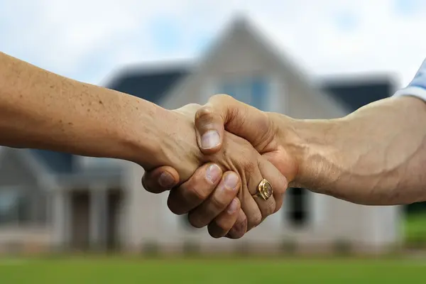 Handschlag vor einem Haus