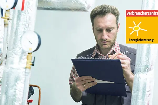 Energieberater macht sich Notizen im Heizungskeller
