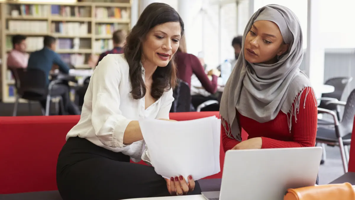 Junge muslimische Frau mit Tutorin