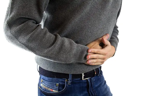 Ein Mann hat Magenschmerzen, fasst sich an den Bauch