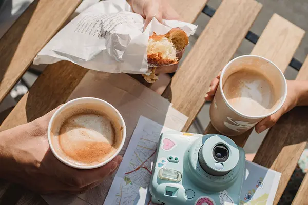 Essen und Getränke "to go" produzieren viel Verpackungsmüll: Auf einem Tisch stehen Kaffeebecher und ein eingepacktes Brötchen