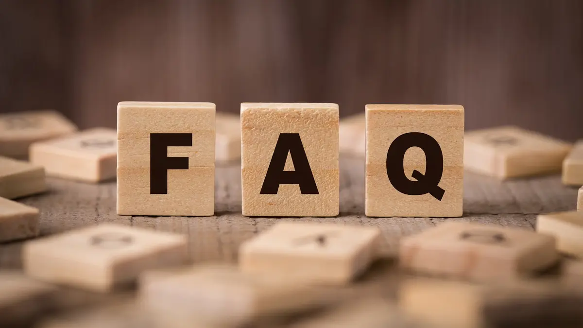 Drei Holzwürfel tragen die Buchstaben FAQ.