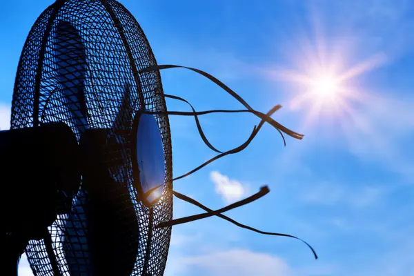 Schwarzer Ventilator unter freiem Himmel mit scheinender Sonne