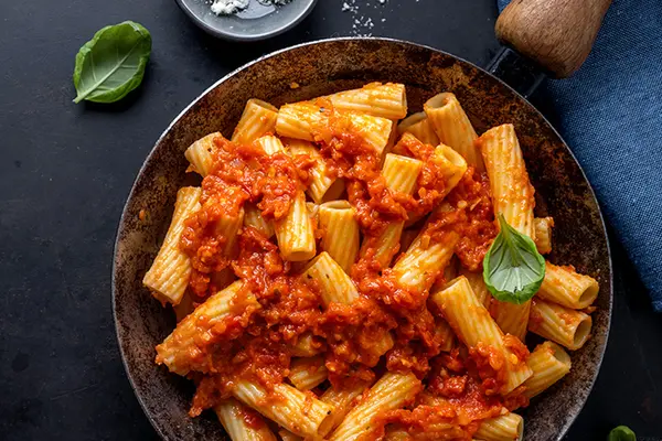 Nudeln in Tomatensauce auf einem dunklen Teller