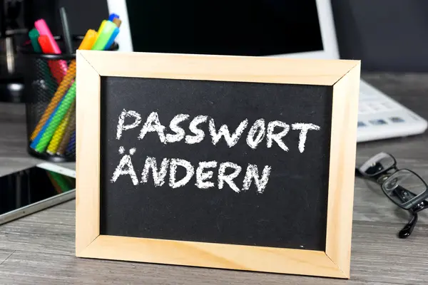 Vor einem Computer steht ein Schild und erinnert daran, das Passwort zu ändern.