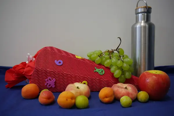 Schultüte mit Obst und einer Alu-Getränkeflasche.