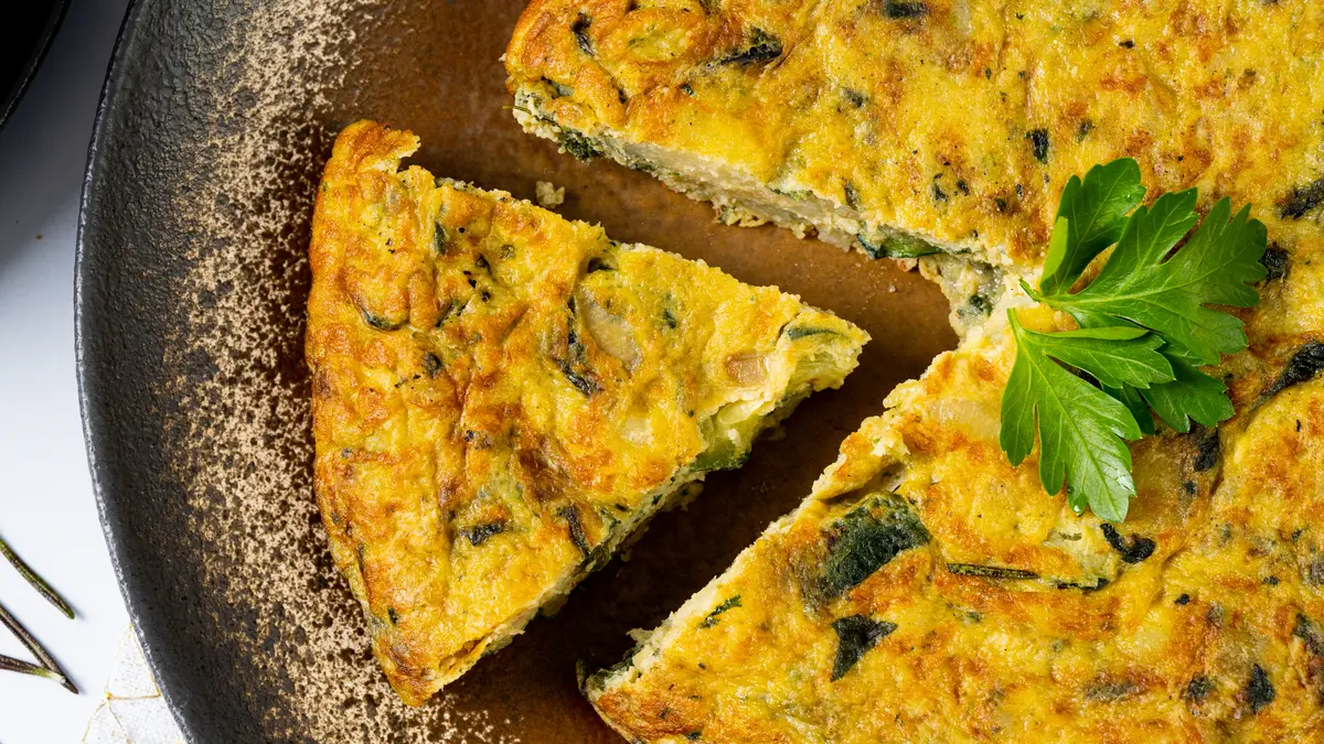Frittata mit einem Stück herausgeschnitten auf einem Teller