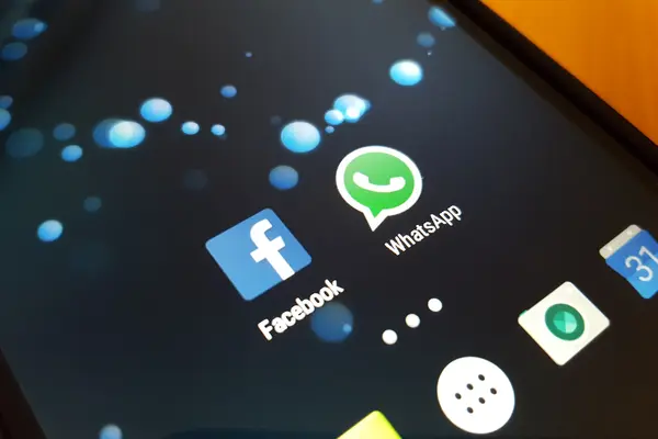 Smartphone mit Logos WhatsApp und Facebook