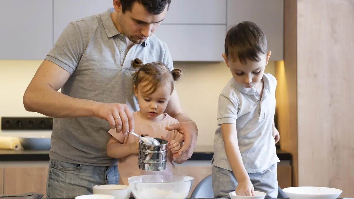 Mann und zwei kleine Kinder backen in der Küche 