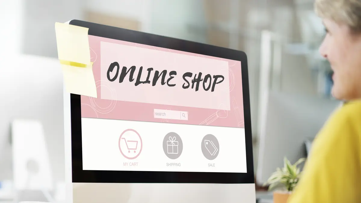 Eine Frau sitzt am PC beim Online Shopping