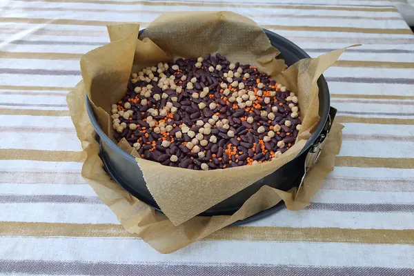 Kichererbsen, Bohnen und Linsen liegen in einer Kuchenform