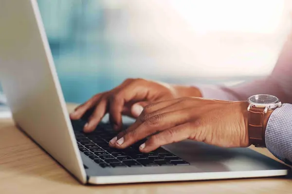 Mann tippt auf Laptop