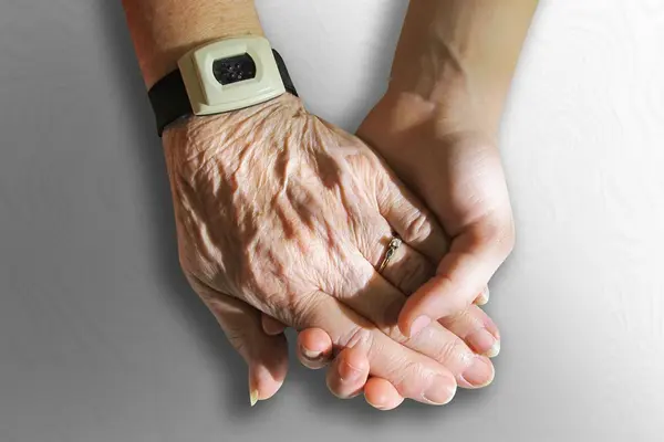 eine junge Hand hält eine alte