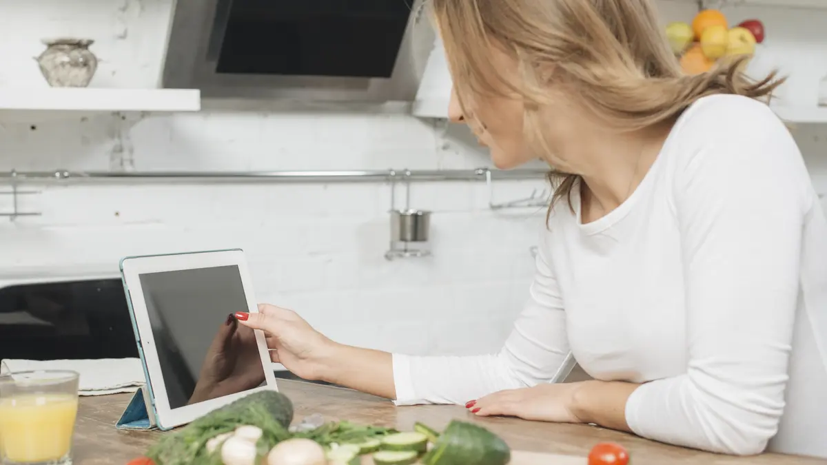 Frau mit Tablet in der Küche