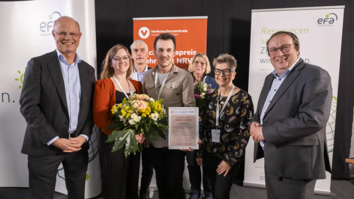 Gruppe mit Gewinnern posiert bei der Preisverleihung vor Banern