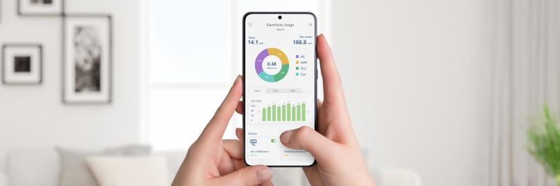 Wohnzimmer, Person hält Smartphone mit Stromverbrauch-App in der Hand