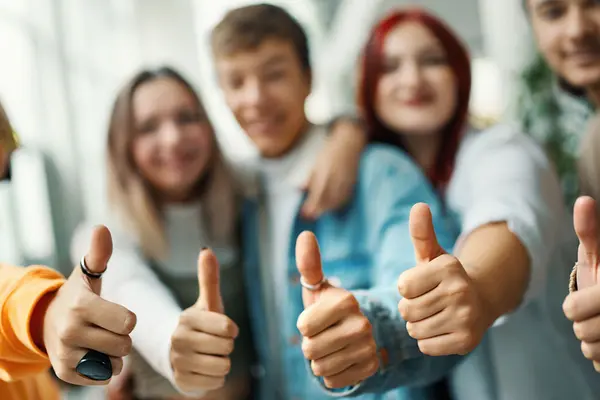 Vier jugendliche  unscharf in Hintergrund, die das "Daumen-hoch"-Symbol machen