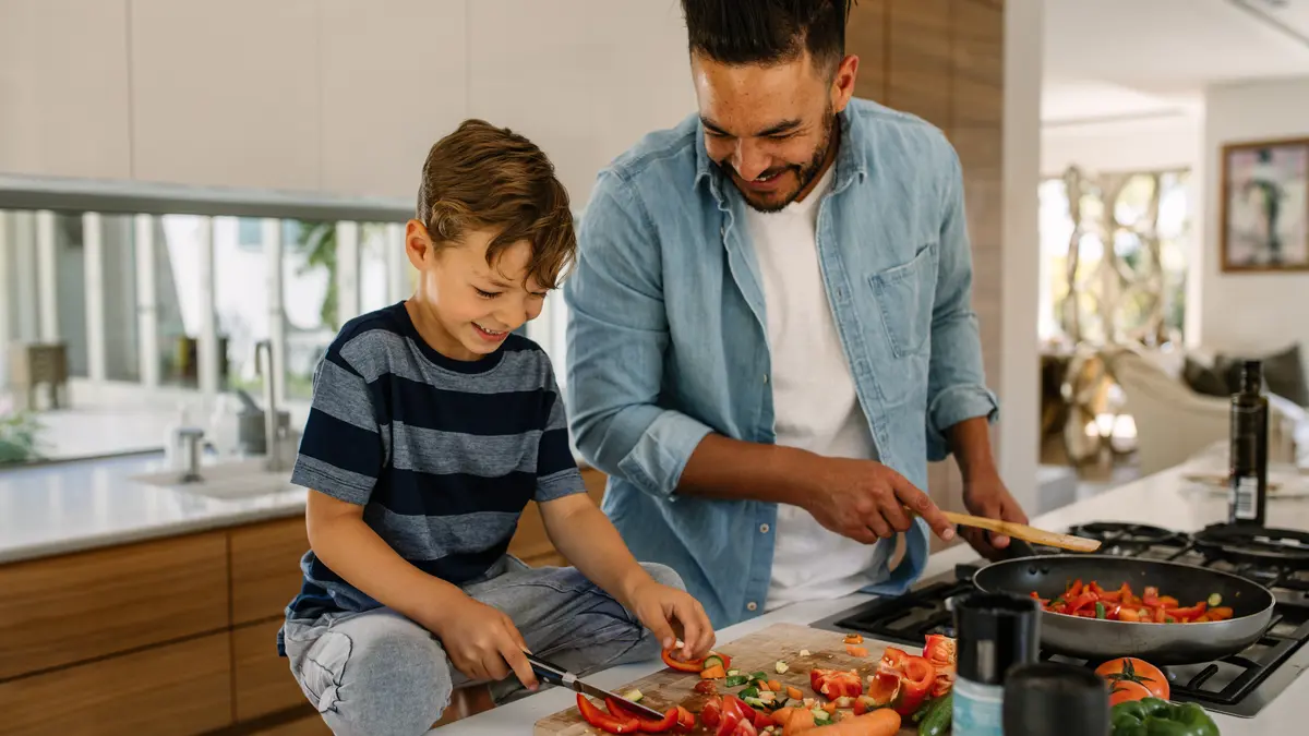 Ein Mann und ein kleiner Junge stehen in der Küche und bereiten Essen zu