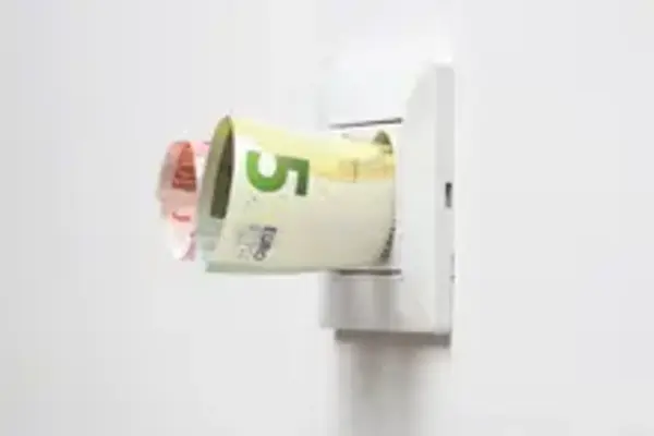 Fünf Euro stecken in einer Steckdose