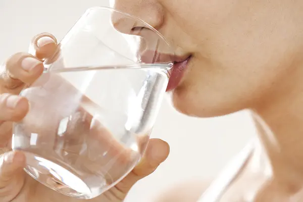 Frau trinkt Wasser aus einem Glas 