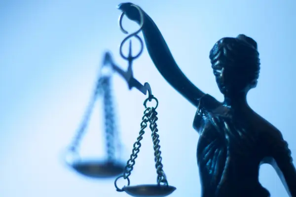 Nahaufnahme der Justizia mit verbundenen Augen und der Wagschale in einer erhobenen Hand