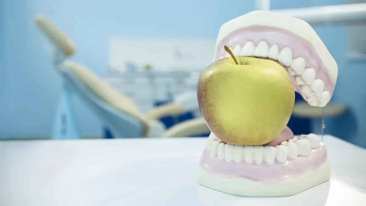 Apfel in einem künstlichen Gebiss