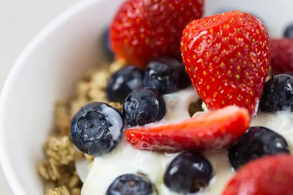 Schüssel mit Joghurt, Früchten und Müsli in Nahaufnahme