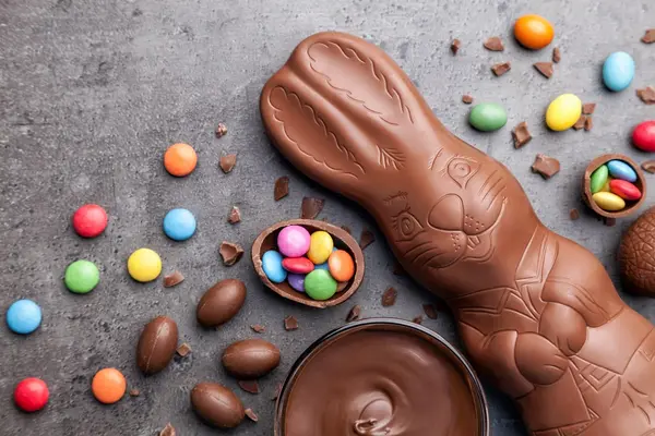 Ein Schokoladenosterhase umgeben von Schokoladeneiern und Schokoladenlinsen.