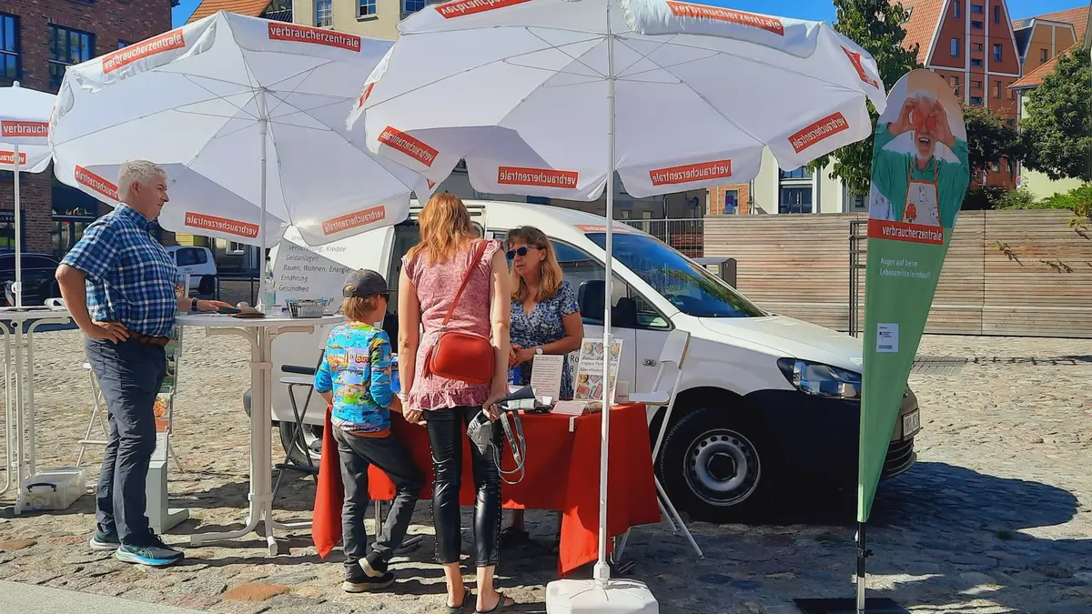 Sonnenschirme um einen Stand von der Verbraucherzentrale MV