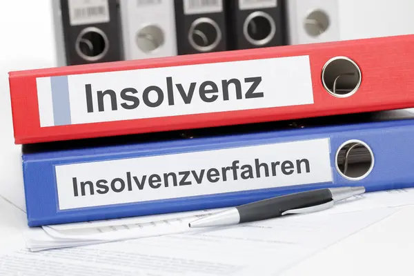 Zwei übereinander liegende Aktenordner, einer mit der Aufschrift Insolvenz, einer mit Insolvenzverfahren